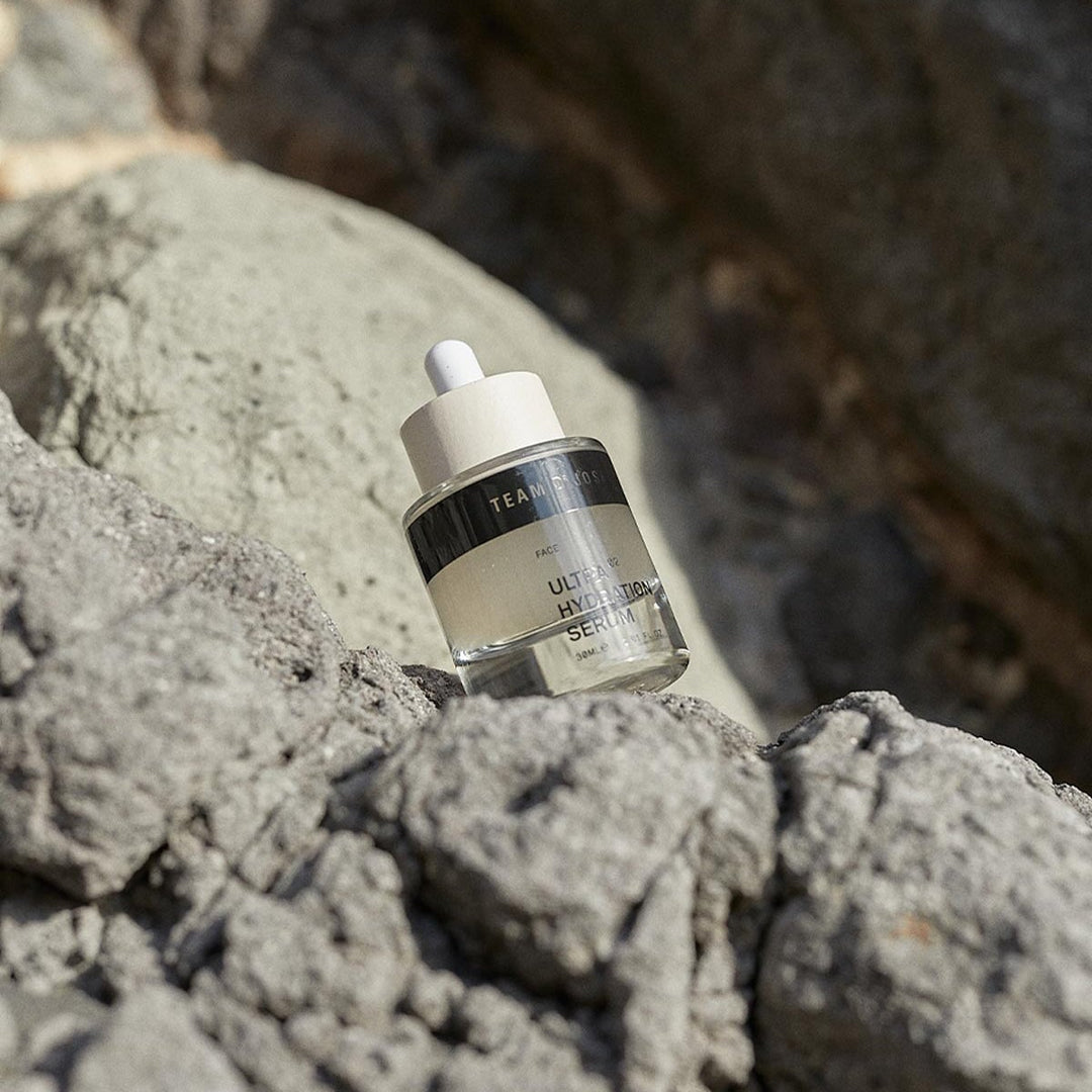 Ultra Hydration Serum von TEAM DR JOSEPH – dekorativ platziert auf Felsen und Naturstein North Glow