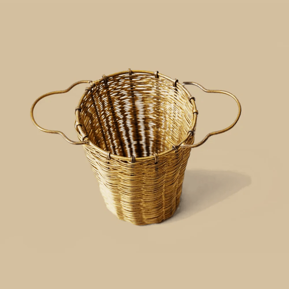 Anima Mundis Wooven Brass Large Tea Strainer - großes Teesieb vor cremefarbenem Hintergrund.