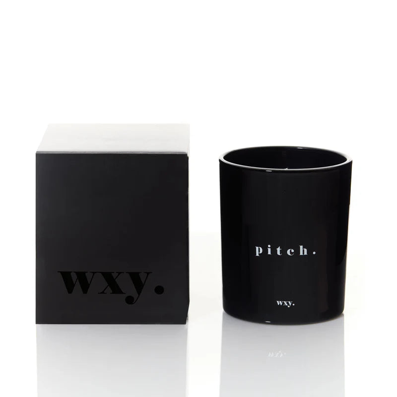 Kerze pitch im schwarzen Glas von wxy. daneben Produktverpackung.