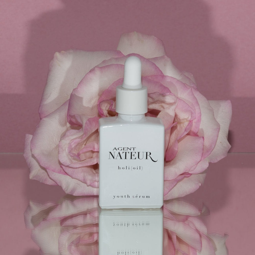 Agent Nateur Holi (Oil) weißer Flakon vor rosa Rose und rosa Hintergrund