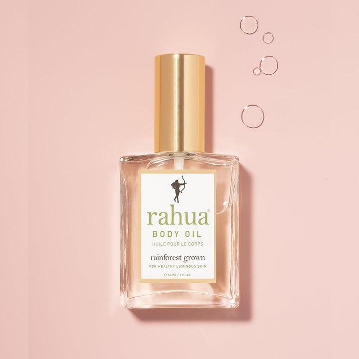 Rahua Body Oil Flasche vor rosafarbenem Hintergrund.