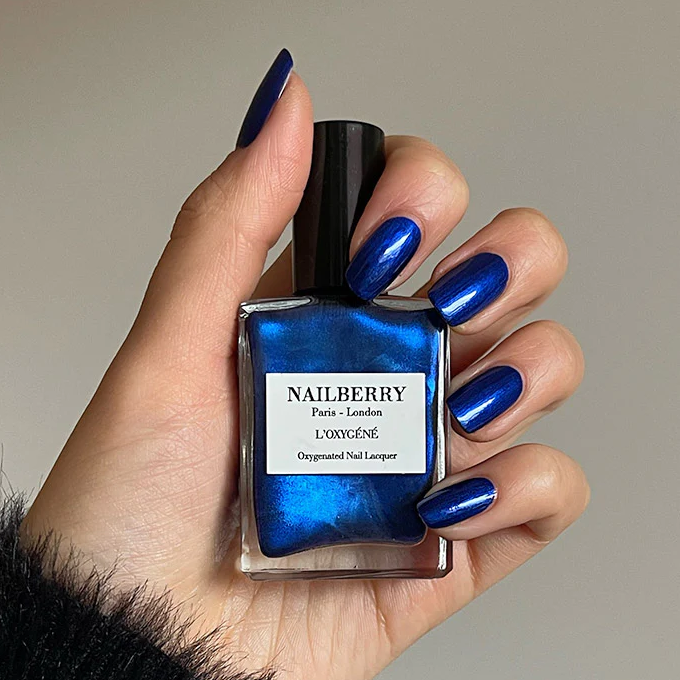 Hand hält Nailberry Nagellackflasche Blue Moon NEW MOON COLLECTION 2022.  North Glow