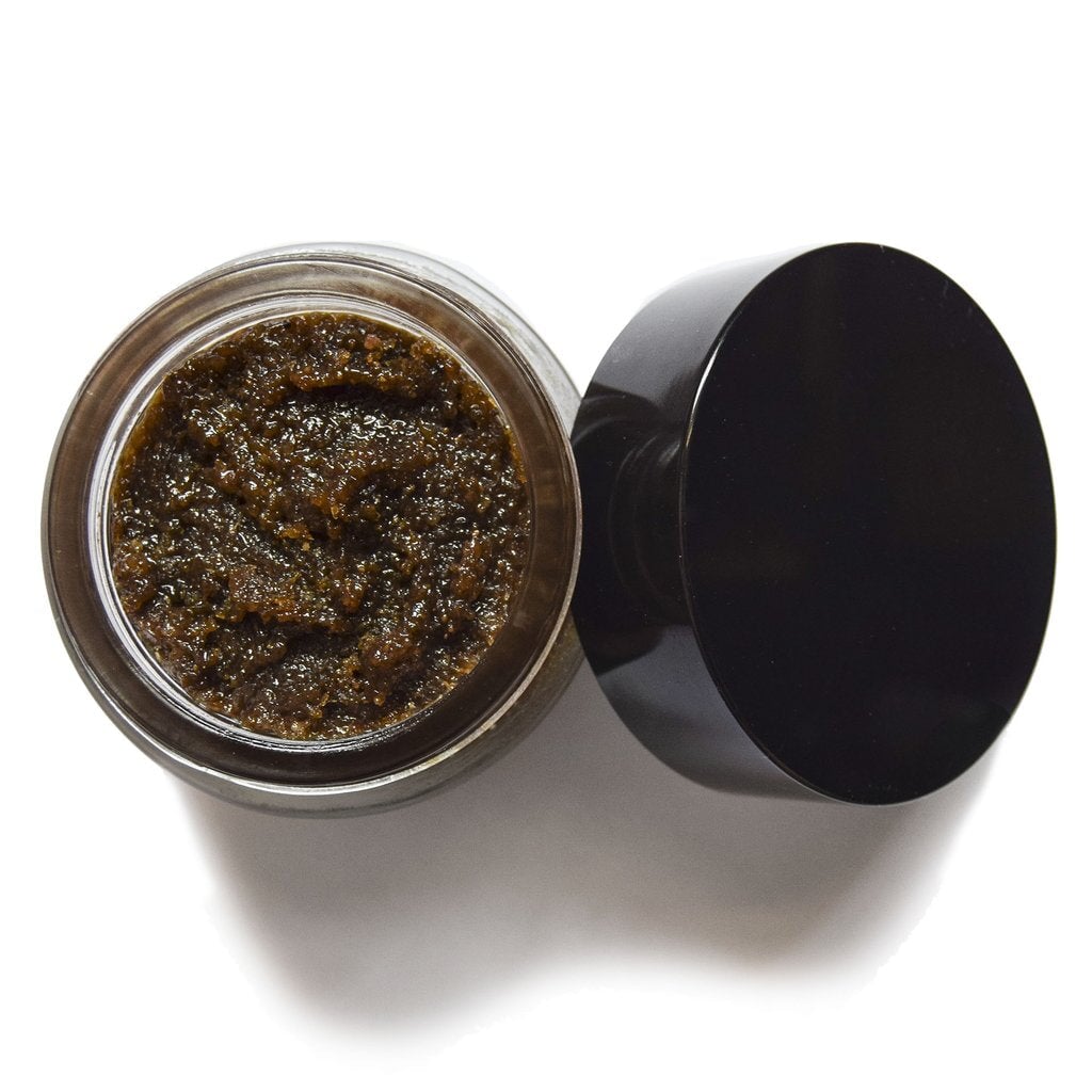 Aus der Vogelperspektive sieht man ein offenes UMA Absolute Anti Aging Body Scrub Schraubglas mir einer körnigen, braunen Masse. North Glow