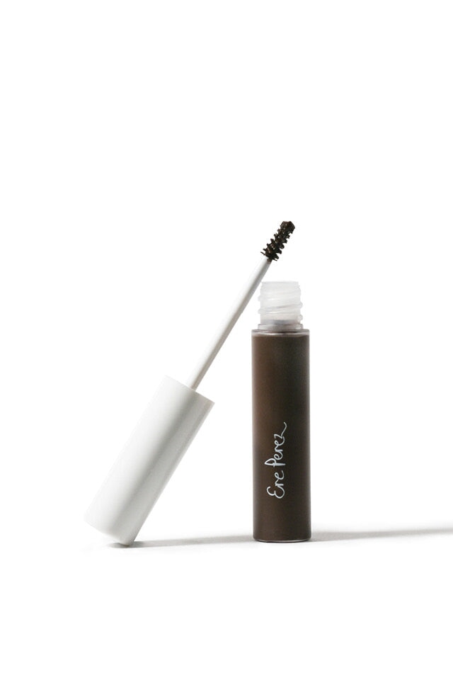 Bürste lehnt an offener Argan Brow Hero Tube vor weißem Hintergrund.