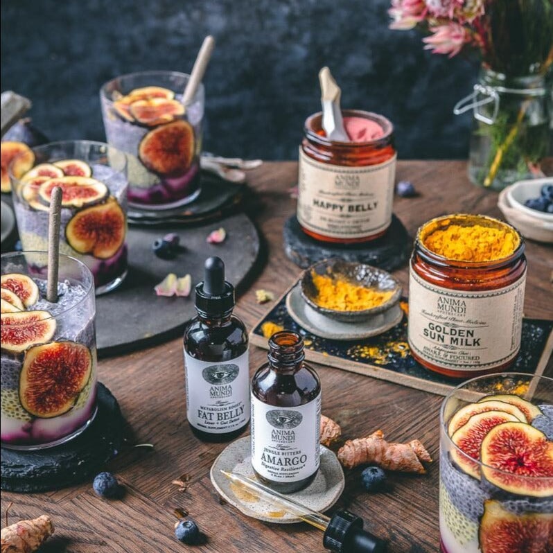 Verschiedene Anima Mundi Produkte stehen auf einem dekoriertem Holztisch.