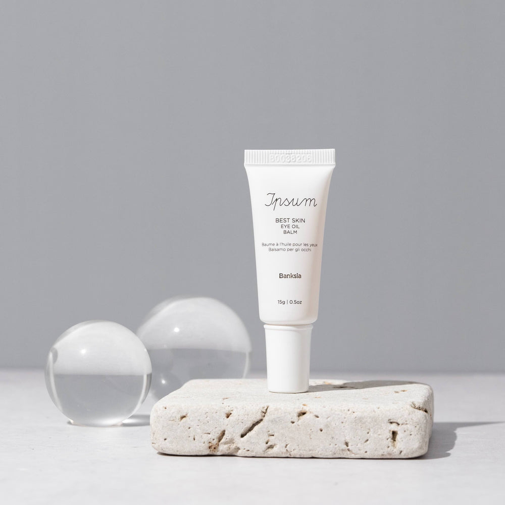  Ipsum Best Skin Eye Oil Balm Tube steht auf einer Steinplatte.