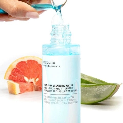 Odacité Blue Aura Mizellenwasser wird in die Flasche gefüllt – Aloe Vera und Grapefruit im Hintergrund.