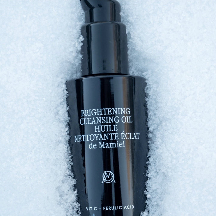 De Mamiel Brightening Cleansing Oil Flakon im weißem auf weißem Hintergrund