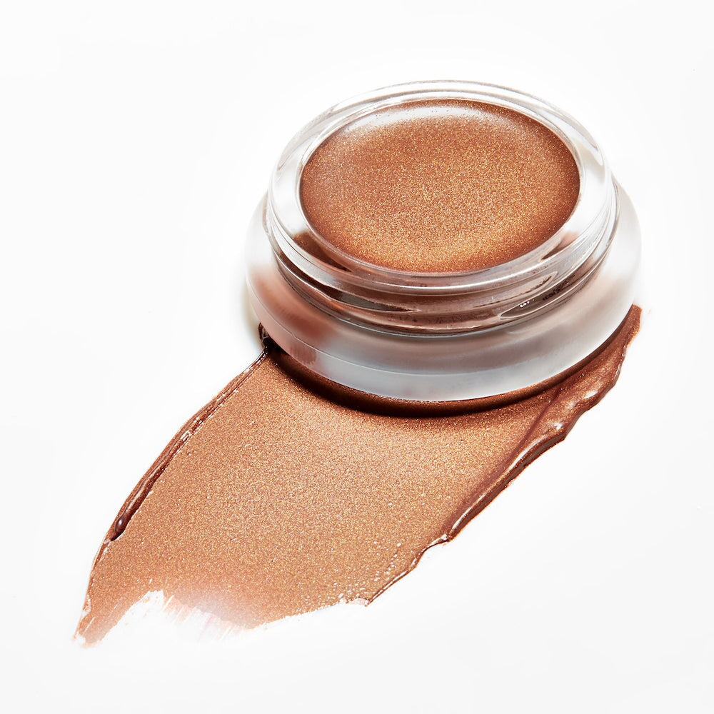 Offener Glastiegel Buriti Bronzer von RMS mit Farb- und Texturbeispiel vor weißem Hintergrund.