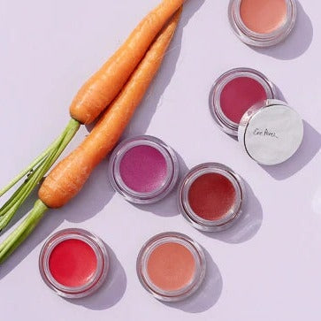 Offene Tiegel der Ere Perez Carrot Colour Pots in verschiedenen Farben aus der Vogelperspektive stehen neben 2 Karotten.