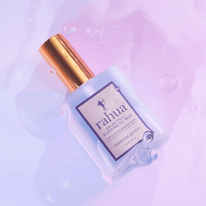 Rahua Color Full Glossing Oil Mist Flasche liegt auf lilafarbenem Hintergrund.