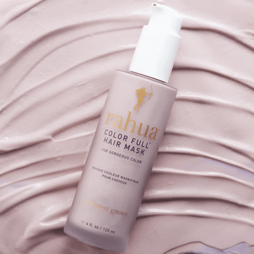 Rahua Color Full Hair Mask Flasche vor lilafarbenem Hintergrund, liegt auf verstrichener Haarmaske als Texturbeispiel.