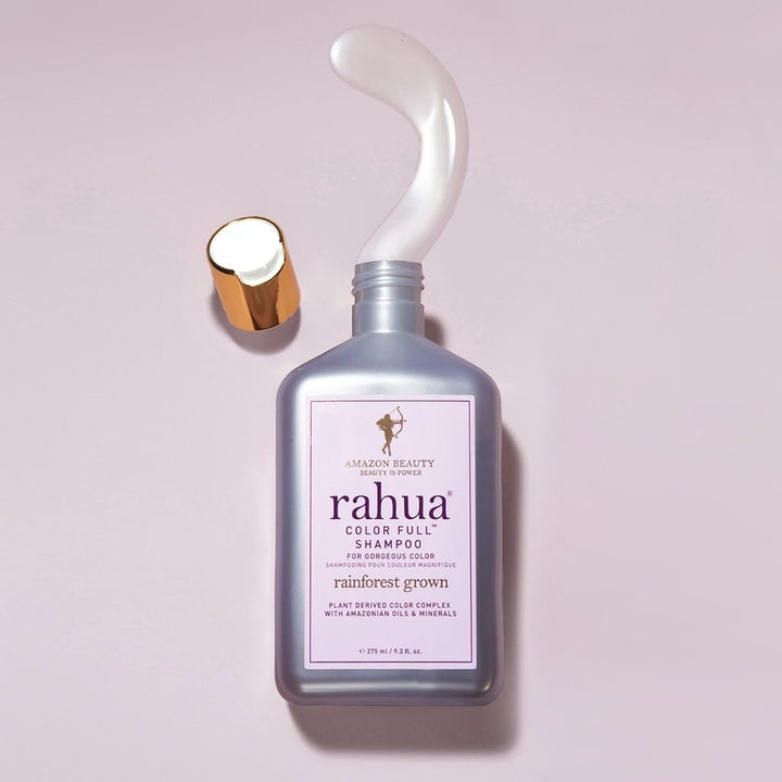 Offene Rahua Color Full Shampoo Flasche mit Texturbeispiel auf rosafarbenem Hintergrund.
