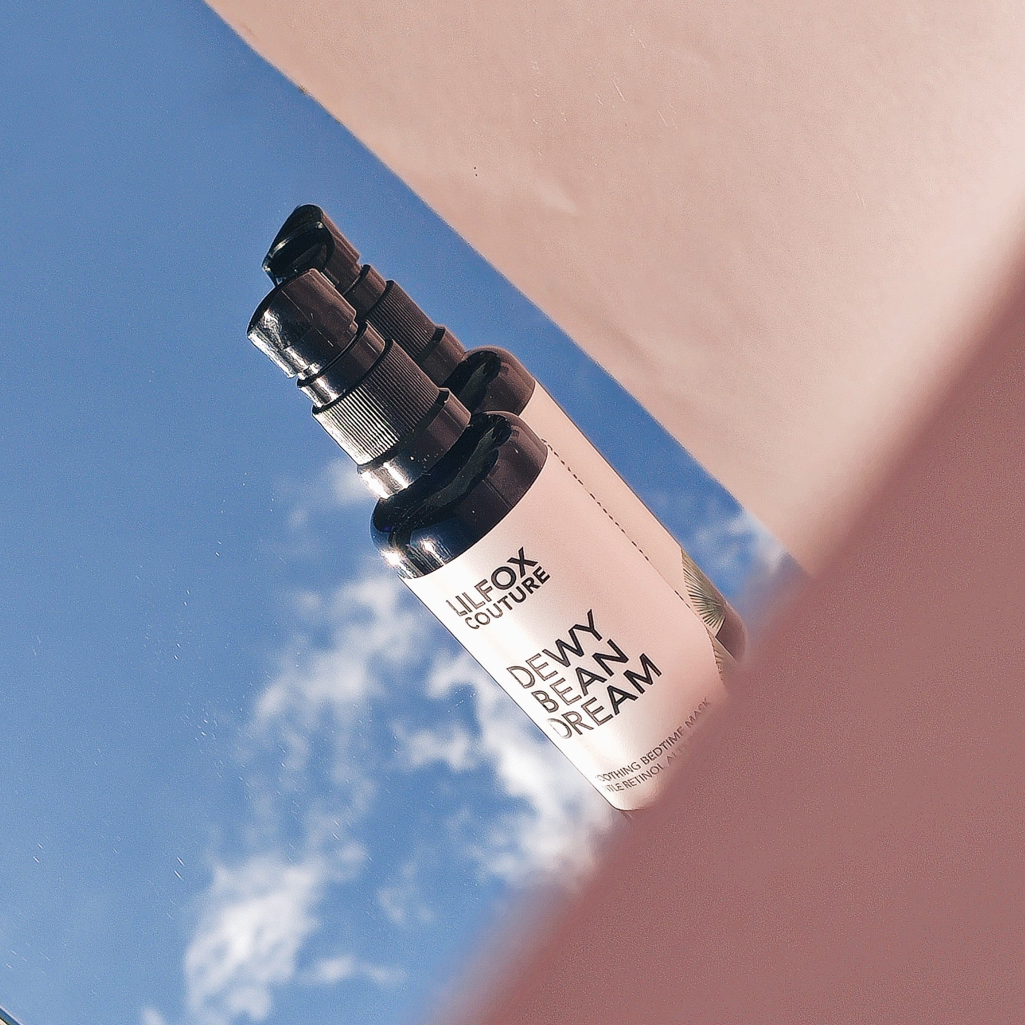 Lilfox Dewy Bean Dream Flaschen im Hintergrund ist der blaue Himmel abgebildet