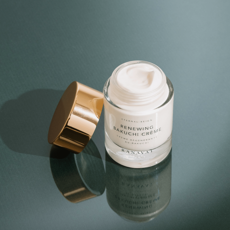 Ranavat Renewing Bakuchi Creme mit offenem Tiegel vor grünem Hintergrund