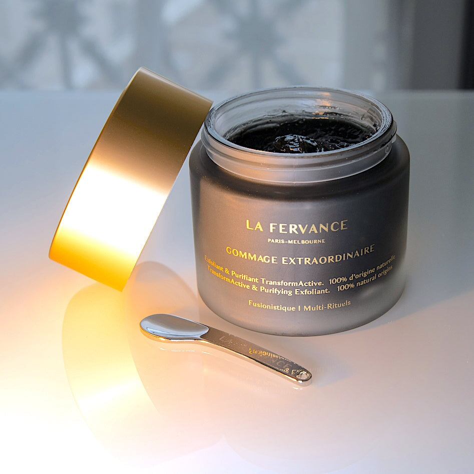 La Fervance Gommage Extraordinaire Tiegel geöffnet mit Spatel und schwarzer Textur auf weißem Tisch