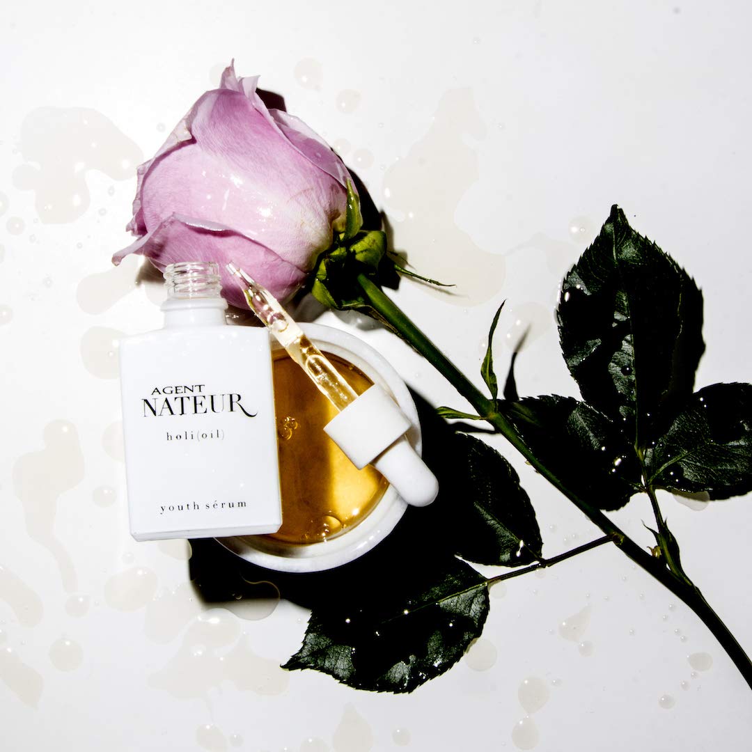 Agent Nateur Holi (Oil) weißer geöffneter Flakon auf rosa Rose und weißem Hintergrund