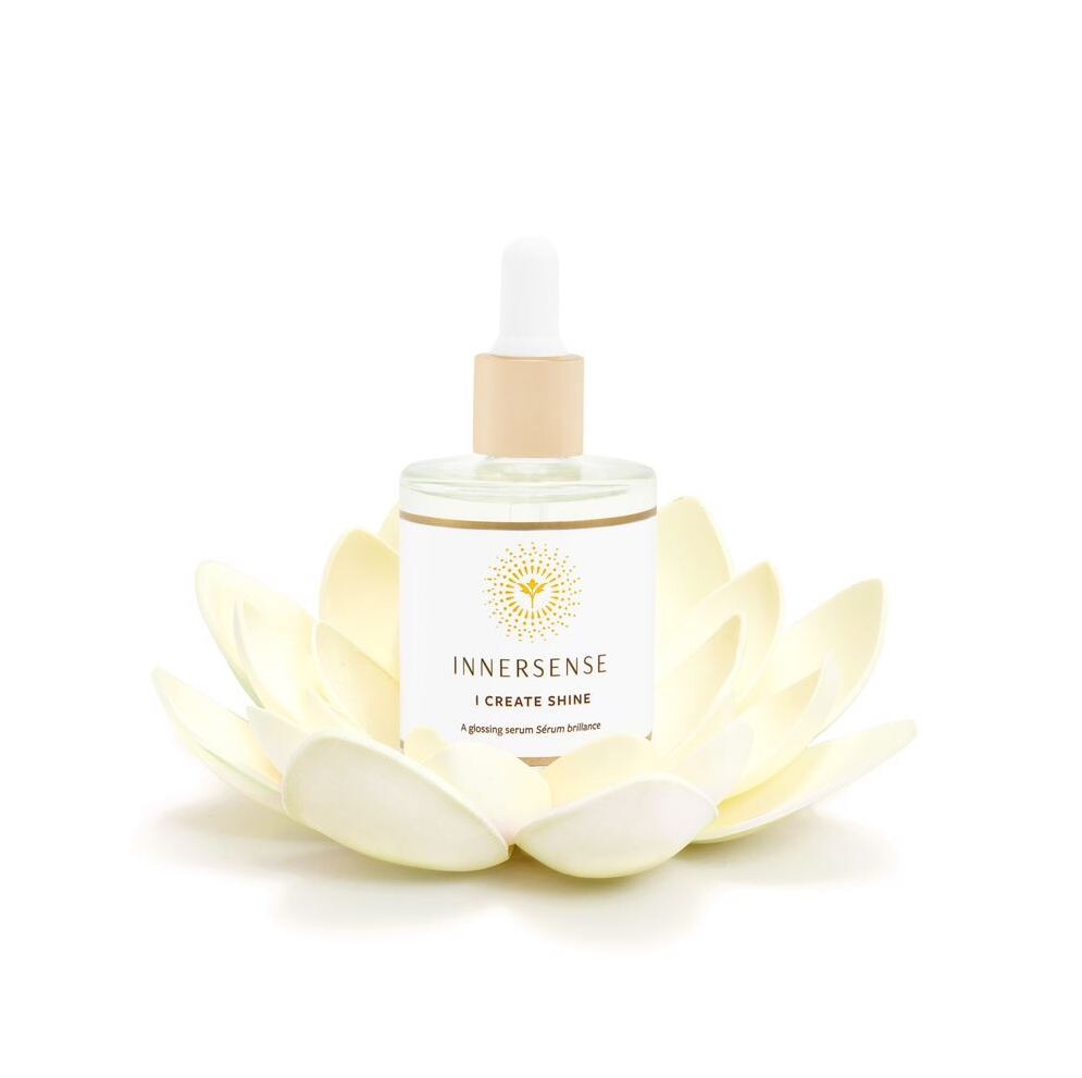 Innersense I Create Shine Pipettenflasche steht in einer weißen Seerosenblüte.