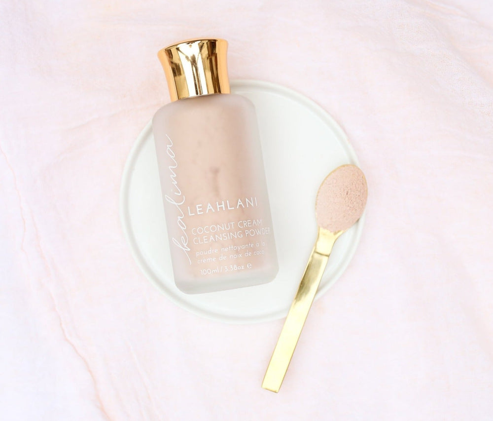 Leahlani Kalima Cleansing Powder Flakon auf weißem Teller mit goldenem Löffel vor weißem Hintergrund