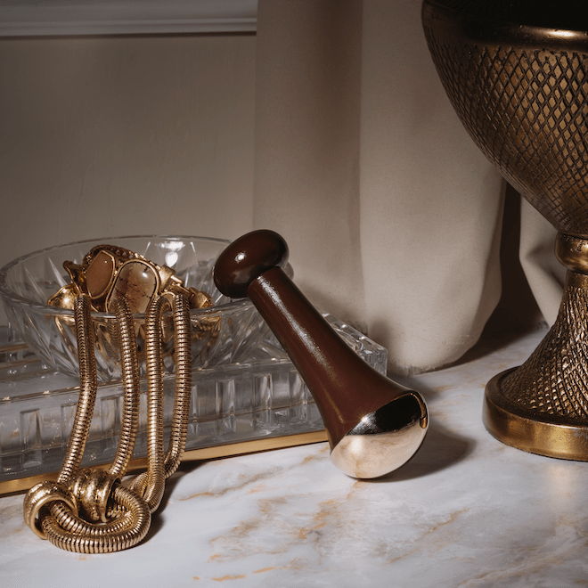 Ranavat Kansa Wand auf Glasschale mit Goldschmuck gelehnt auf weißem Marmortisch 