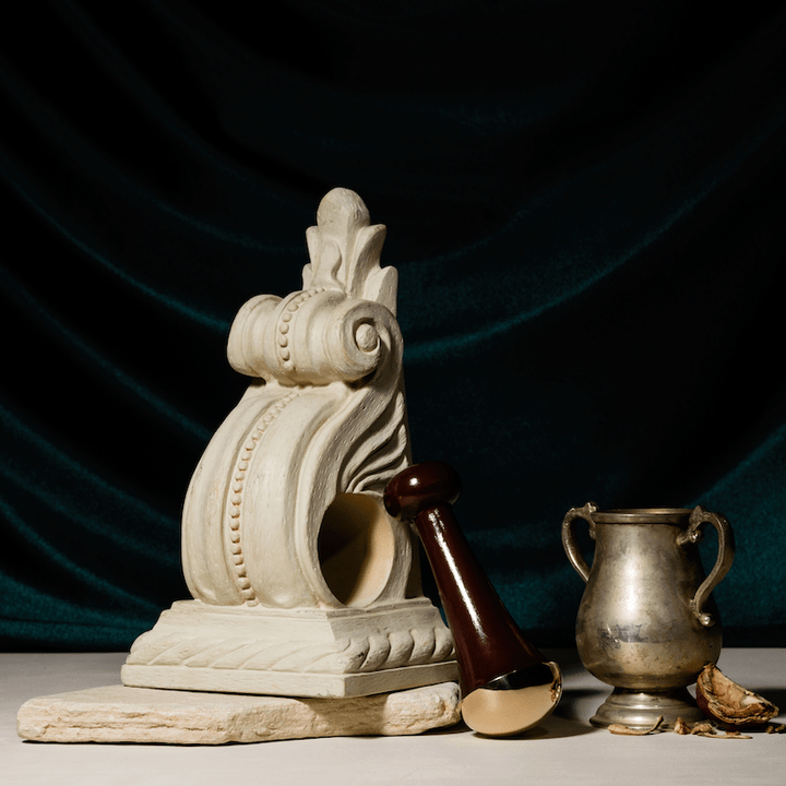 Ranavat Kansa Wand mit goldenem Kelch und weißer Skulptur grüner Vorhang im Hintergrund