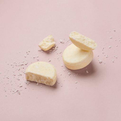 Abhati Suisse Kaveri festes Shampoo Stück liegt zerbrochen auf rosafarbenem Untergrund. North Glow