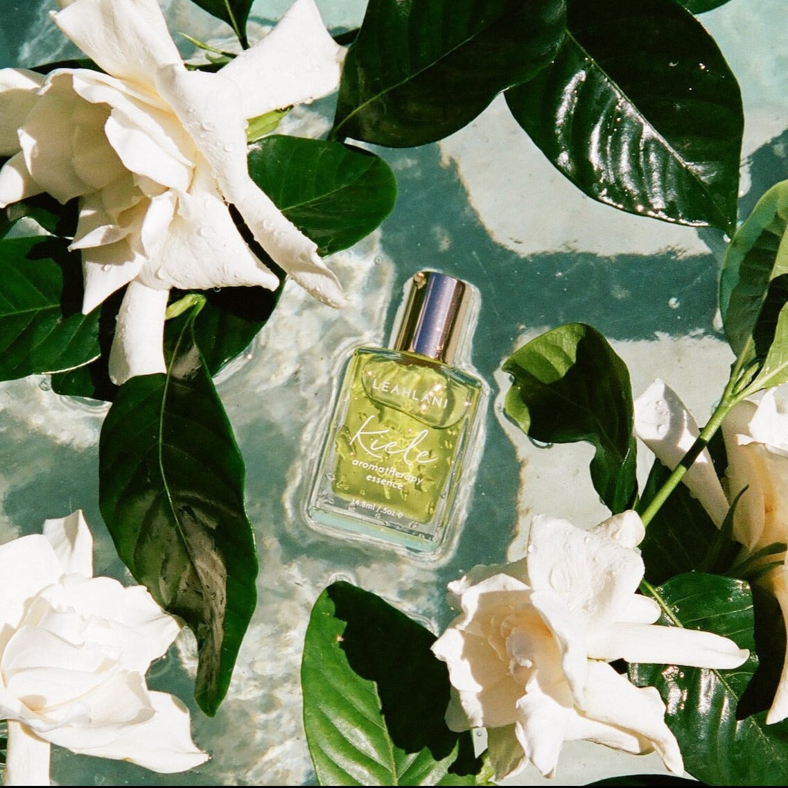 Leahlani Kiele Aroma Essence Flakon im Wasser mit weißen Blüten und Blättern