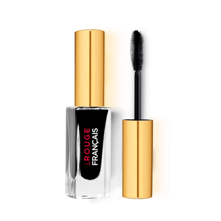 Glasflasche der Mini Mascara Le Noir Cassiopée No 410 steht neben einer Silikonwimpernbürste vor weißem Hintergrund.
