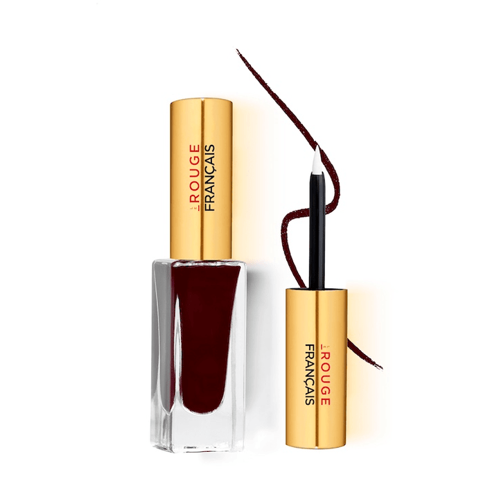 Le Pourpre PERSÉE No 530 Eyliner Glasflasche mit goldenem Deckel steht neben dem Pinsel vor weißem Hintergrund.