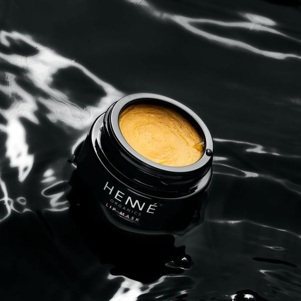 Offener, schwarzer Tiegel der Henné Lip Mask auf schwarzem Untergrund. North Glow