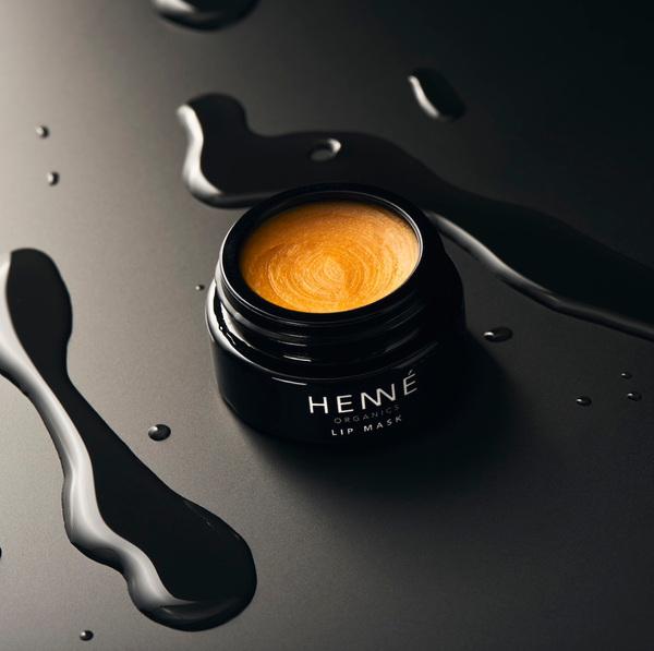 Offener, schwarzer Tiegel der Henné Lip Mask auf schwarzem Untergrund.
