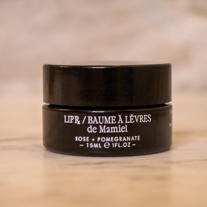 Schwarzer De Mamiel Lip Treatment Tiegel  vor hellem Hintergrund
