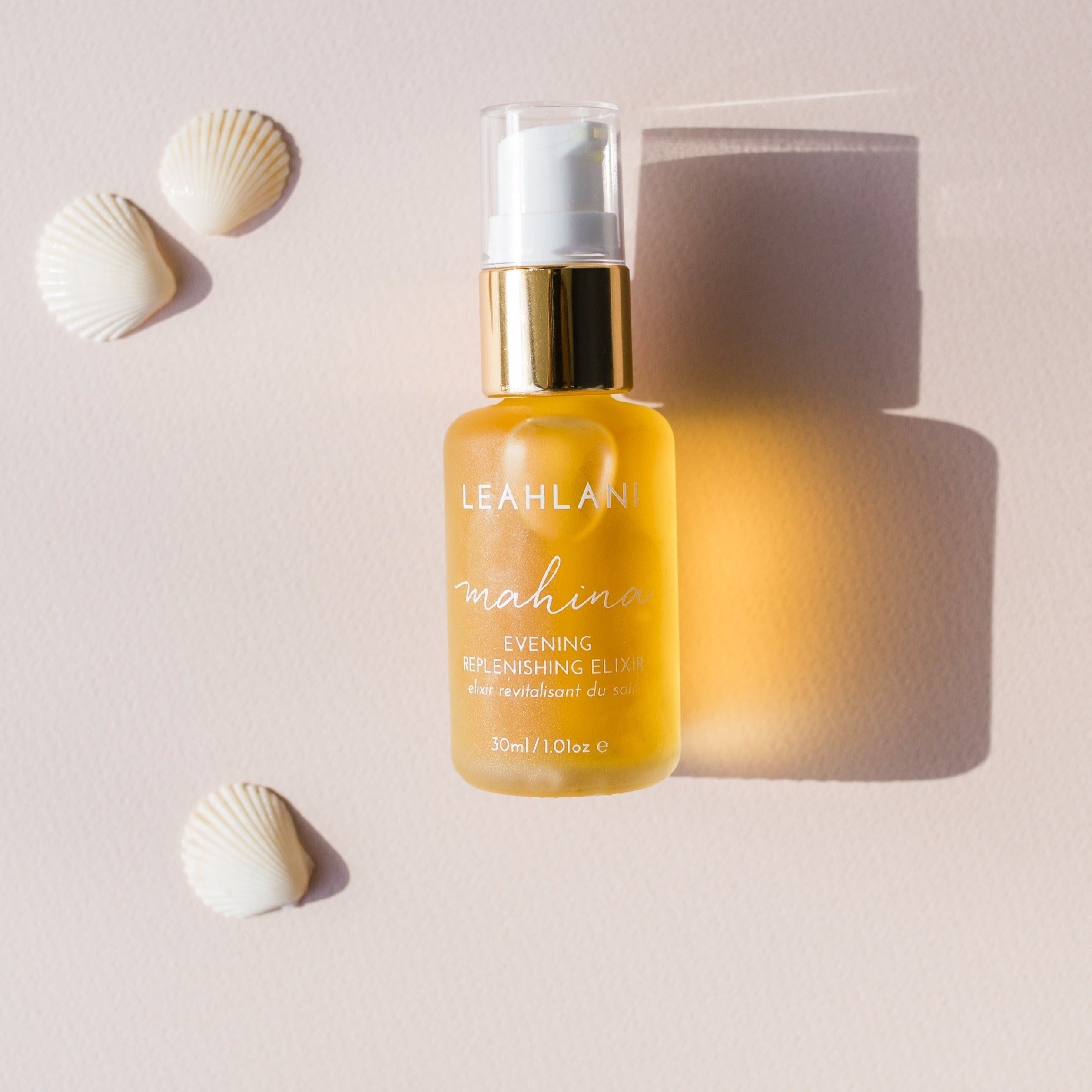 Leahlani Mahina Evening Elixir Flakon mit Muscheln auf hellem Hintergrund