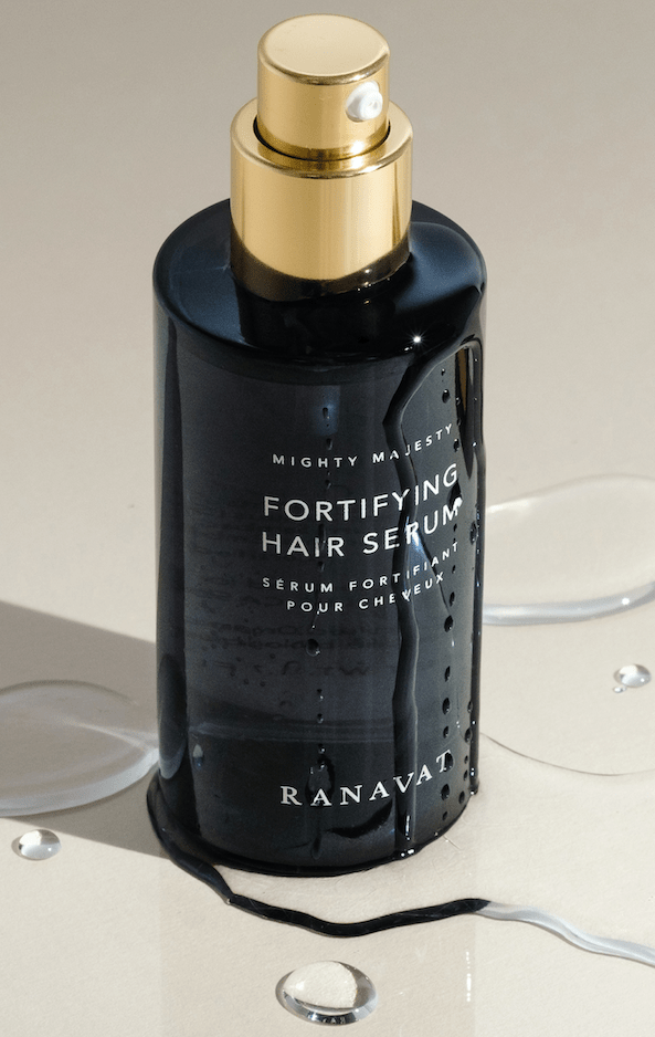 Ranavat Mighty Majesty Haarserum Flakon auf beigen wässrigen Hintergrund