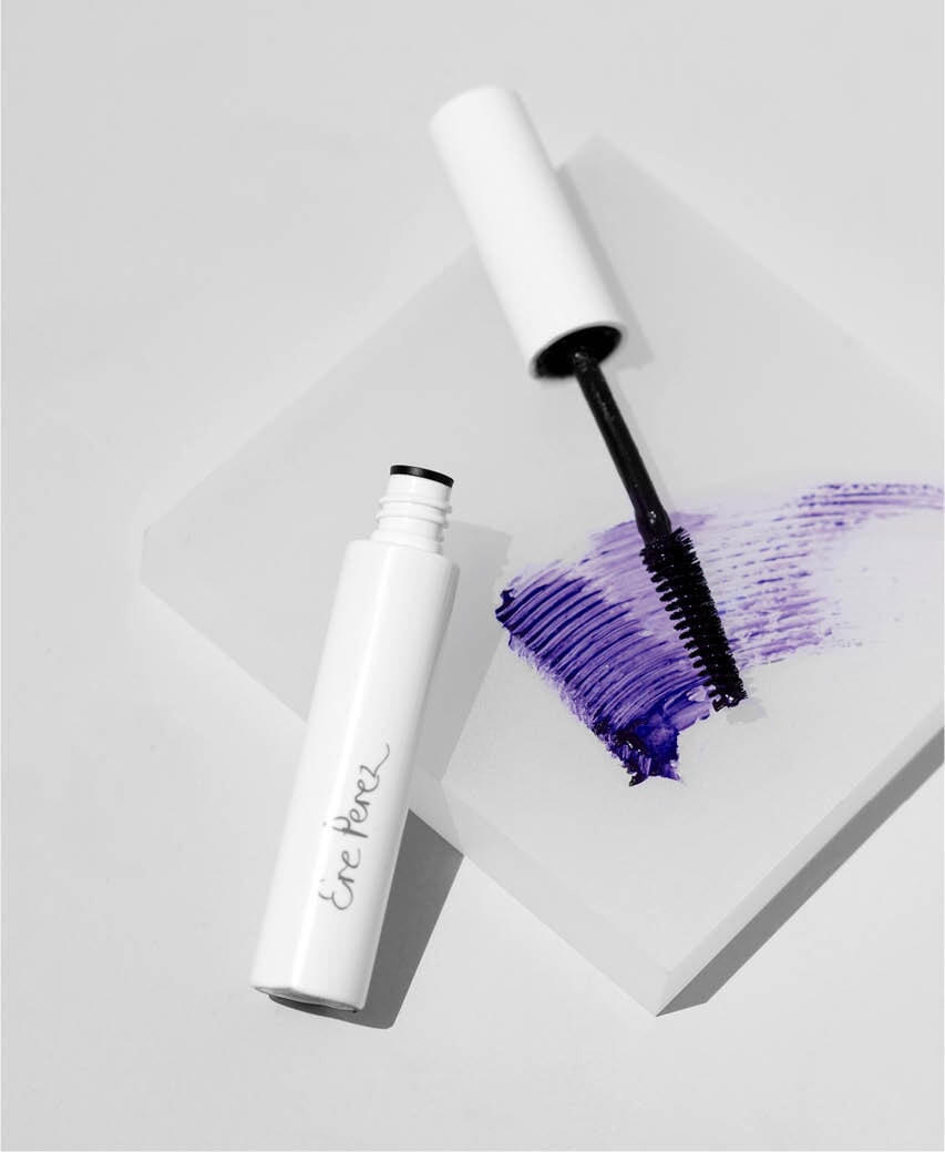 Farb- und Texturbeispiel des Ere Perez Natural Almond Mascara in mauve mit Wimpernbürste auf weißem Untergrund.