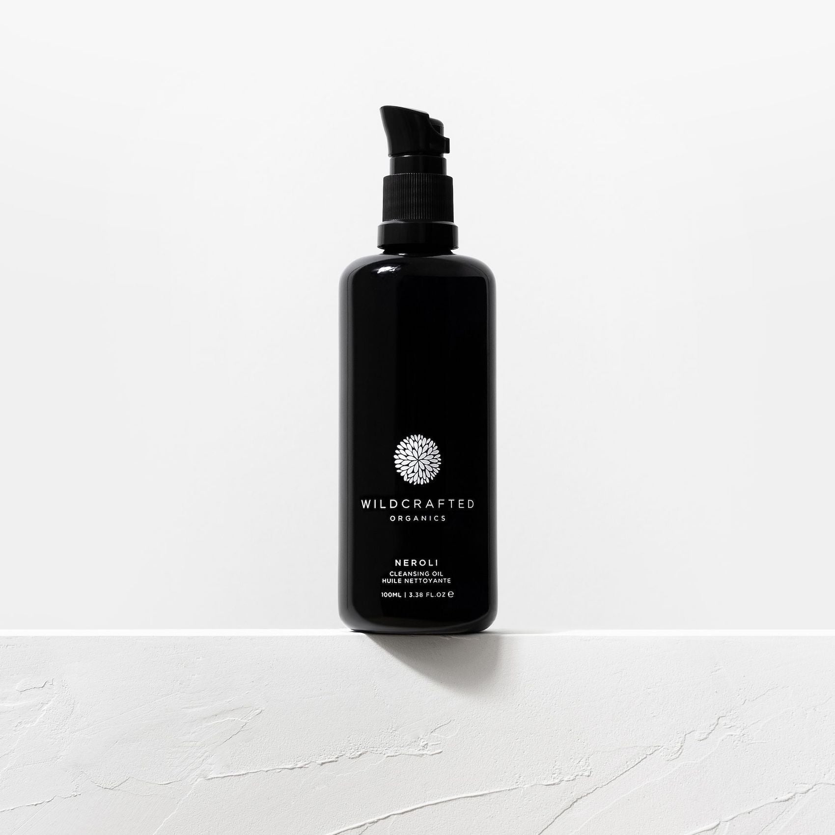 Schwarze Pumpflasche von Wildcrafted Organics Neroli Cleanser vor weißem Hintergrund.
