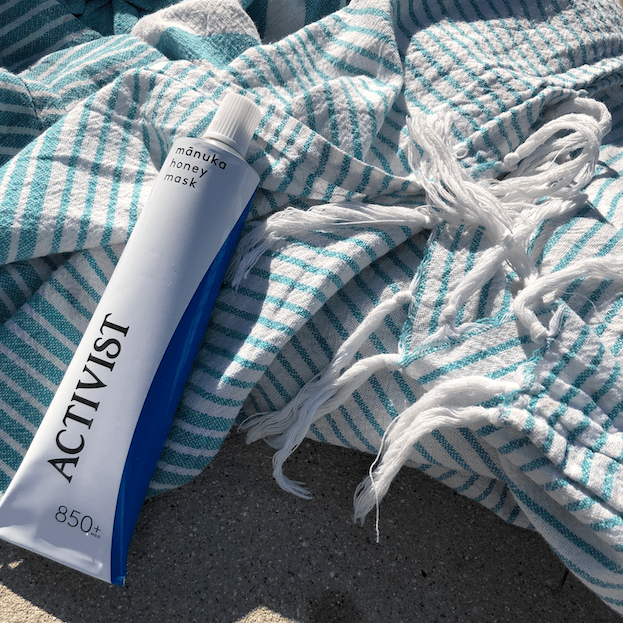 ACTIVIST Manuka Honey Mask Tube auf hellem Strandtuch