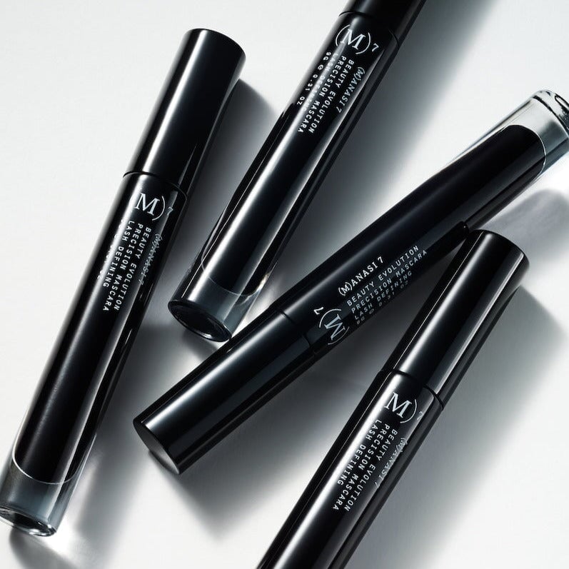 4 Manasi 7 Precision Mascara liegen verstreut auf weißem Hintergrund.