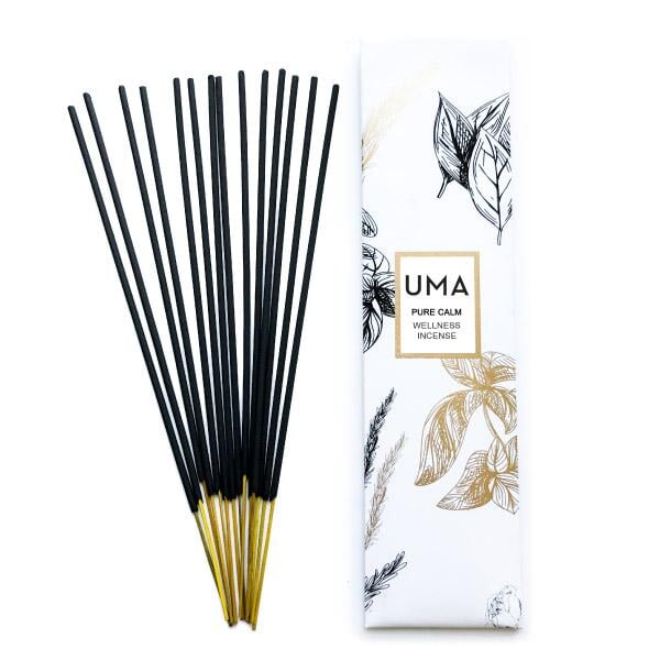 Ein Fächer von UMA Pure Calm Wellness Incense Räucherstäbchen neben der Verpackung stehen vor weißem Hintergrund.