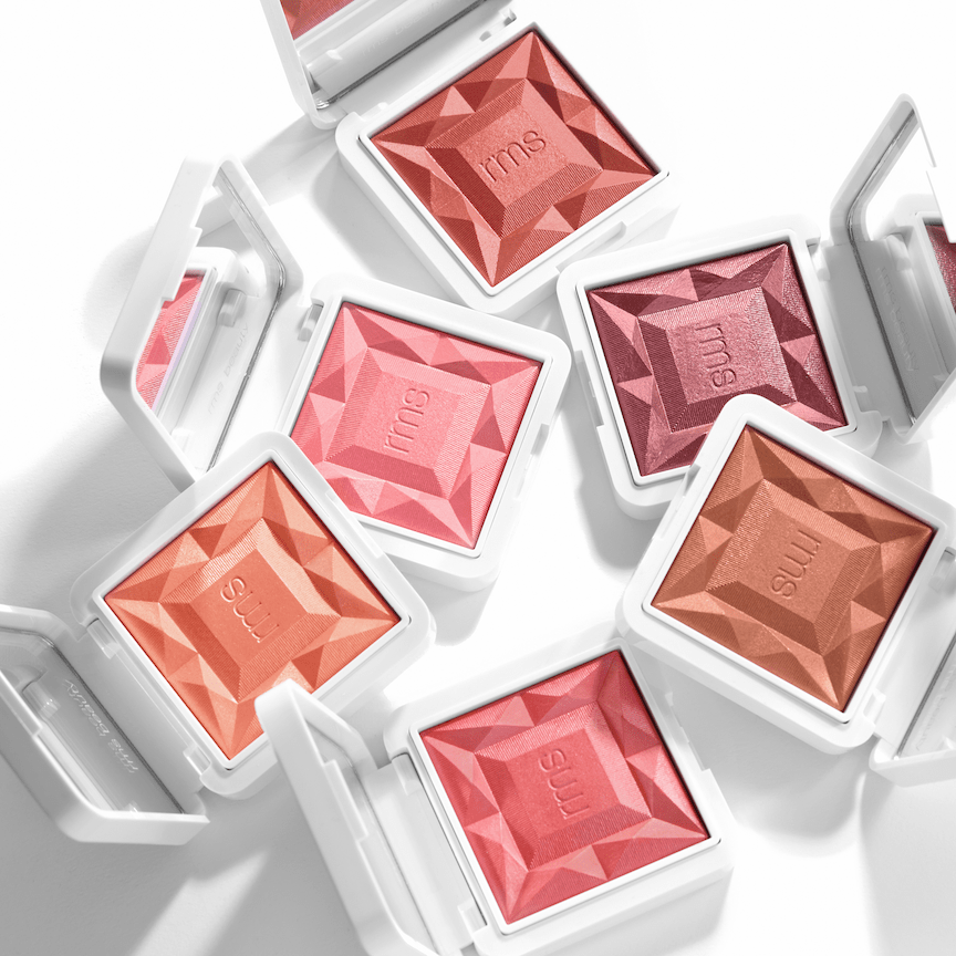 6 offene RMS Blush Puderdosen aus der Vogelperspektive vor weißem Hintergrund. North Glow