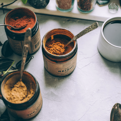 Anima Mundi Schraubglas Reishi steht neben 2 weiteren Anima Mundi Gläsern, alle offen mit Löffeln drin.