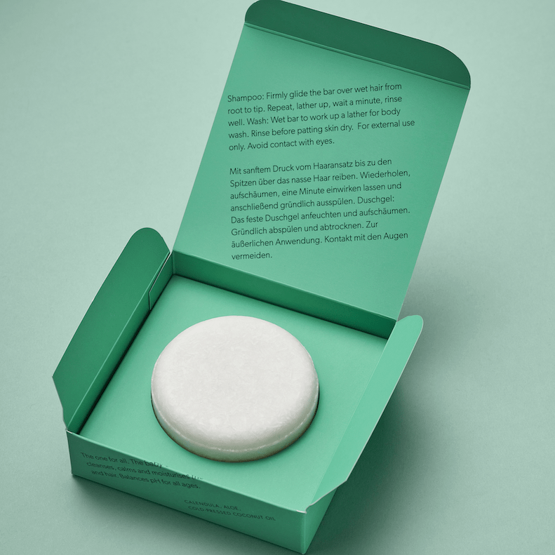 Abhati Suisse Tanu Seifenstück liegt in der grünen Verpackung aus der Vogelperspektive.