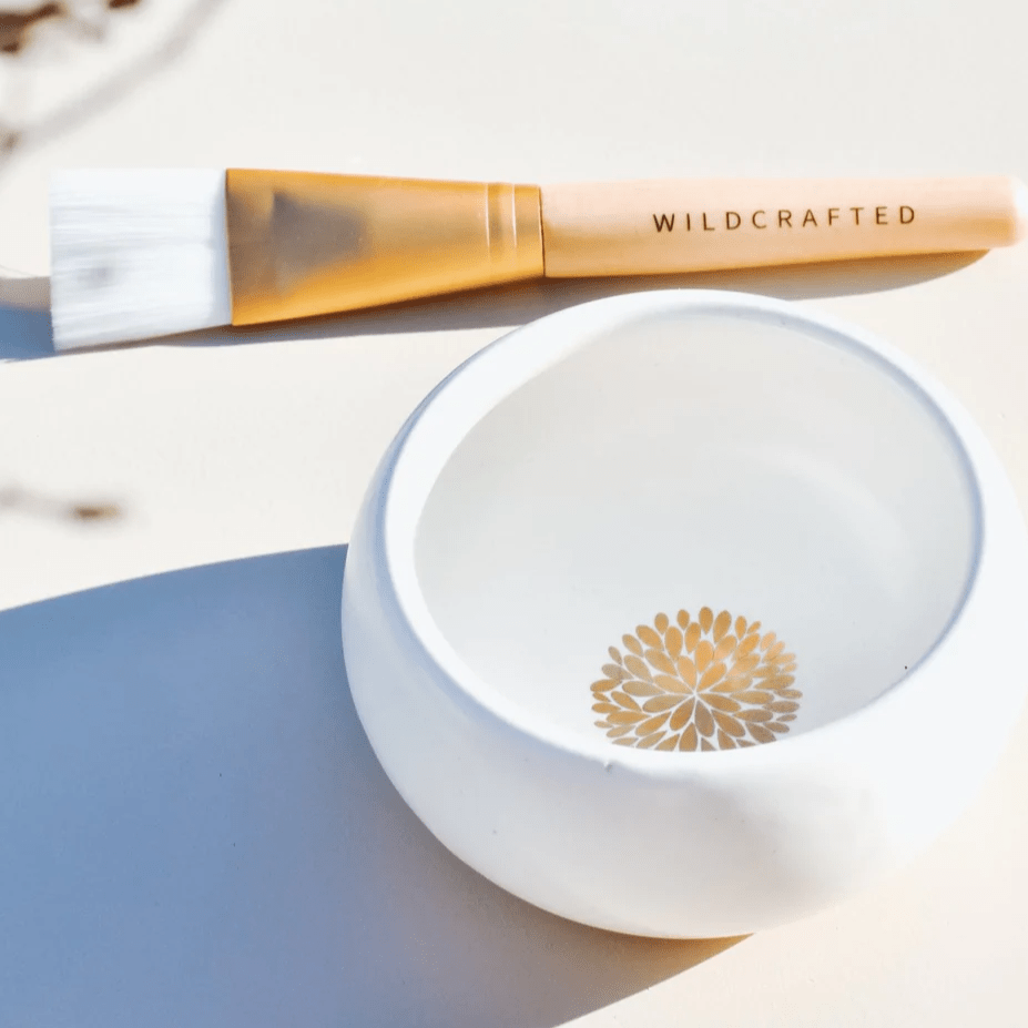 Wildcrafted Organics Vegan Masque Brush liegt neben einem weißem Schälchen.