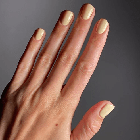 Gepflegte Hand mit helle, gelben Nagellack von Karolin Van Loon – Farbton Beurre Soleil  North Glow