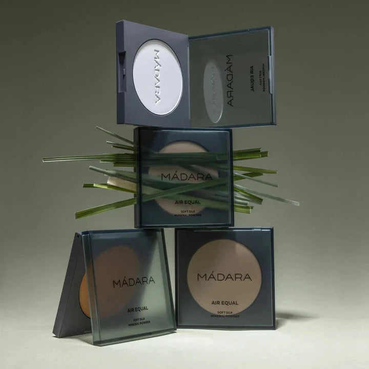Various Air Equal powder compacts in different colors stacked on top of and next to each other.
