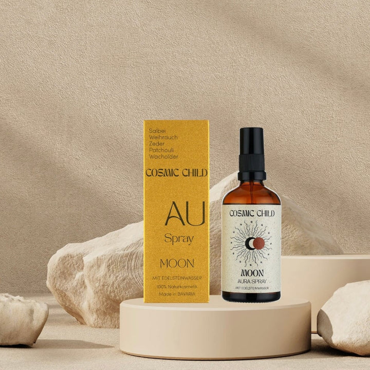 Packaging and pump bottle Aura Spray MOON surrounded by beige stones.