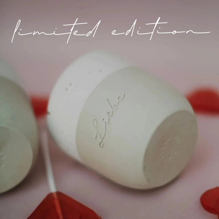 Mug "Love" from Eulenschnitt lying between heart lollipops.