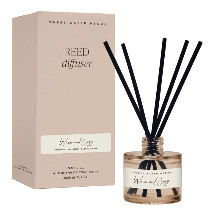 Diffuser Warm and Cozy von Sweet Water Decor mit dekorativen Schilfrohrstäbchen auf hellem Hintergrund