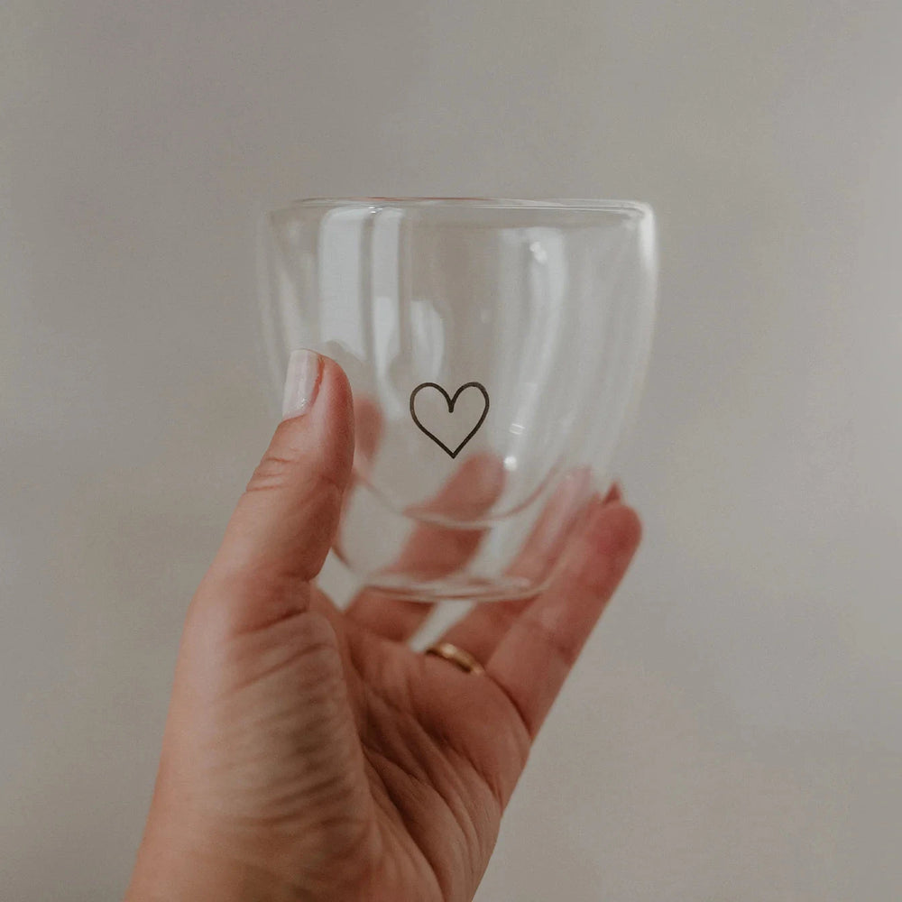Double-walled heart glass with heart from Eulenschnitt is held up by a hand.