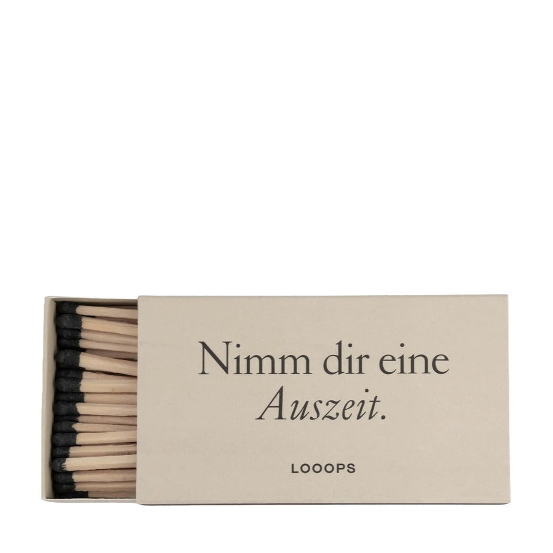 Geöffnete Streichholzverpackung mit Aufschrift "Nimm dir eine Auszeit" von Looops. North Glow